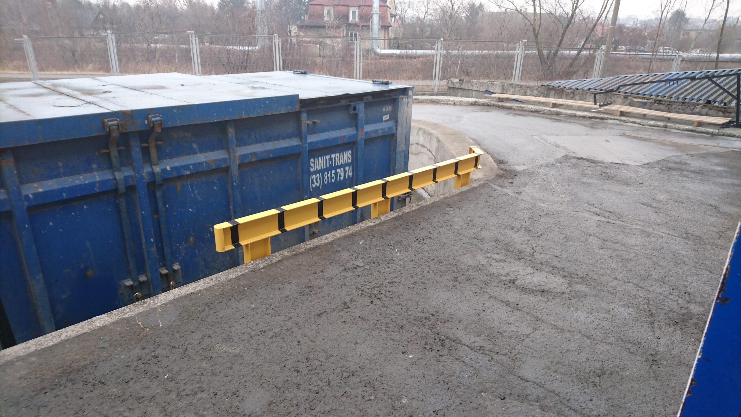 Bariera ochronna przemysłowa w kolorze żółto-czarnym zamontowana na posadzce hali