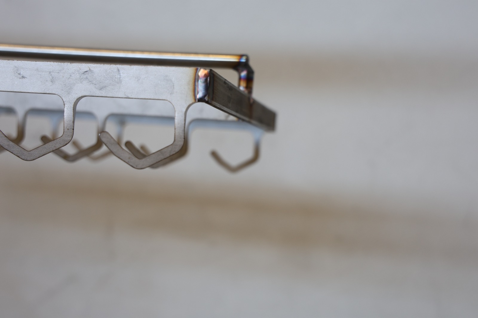 Metalowa zawieszka przemysłowa z rzędami haków, używana do zawieszania detali w procesach produkcyjnych lub obróbki powierzchniowej.