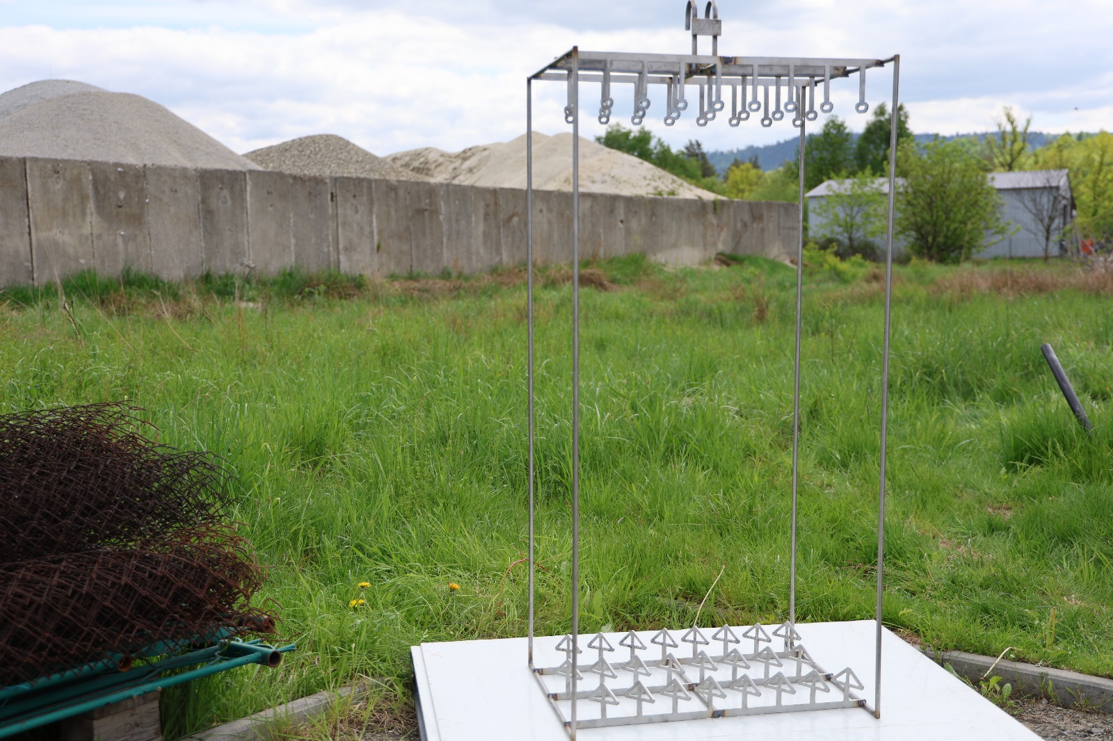 Metalowa zawieszka przemysłowa z rzędami haków, używana do zawieszania detali w procesach produkcyjnych lub obróbki powierzchniowej.