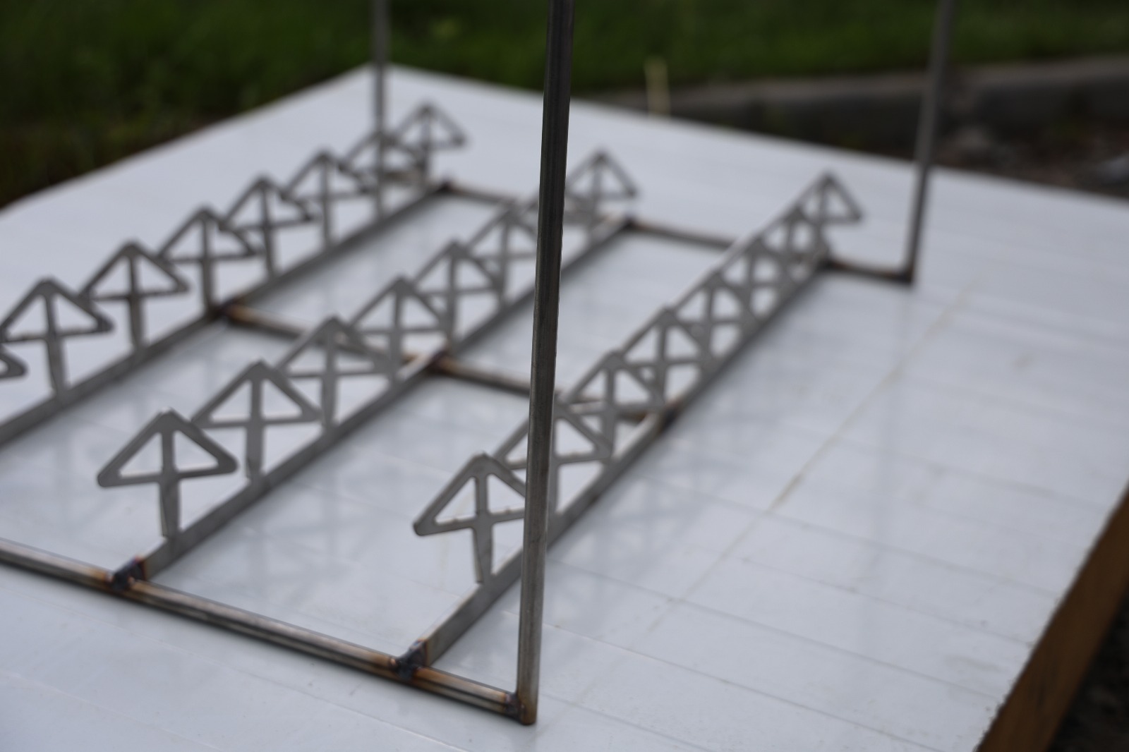 Metalowa zawieszka przemysłowa z rzędami haków, używana do zawieszania detali w procesach produkcyjnych lub obróbki powierzchniowej.