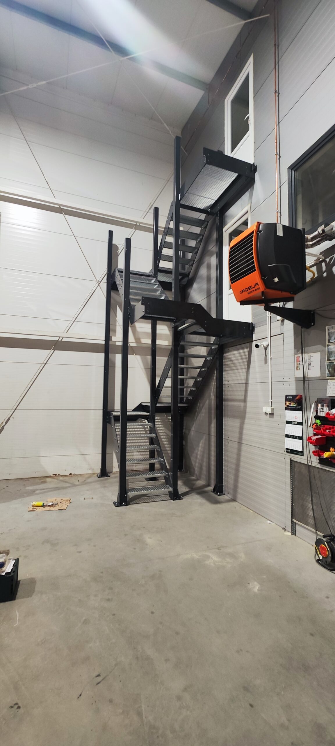 Schody stalowe techniczne prowadzące na antresolę w hali przemysłowej